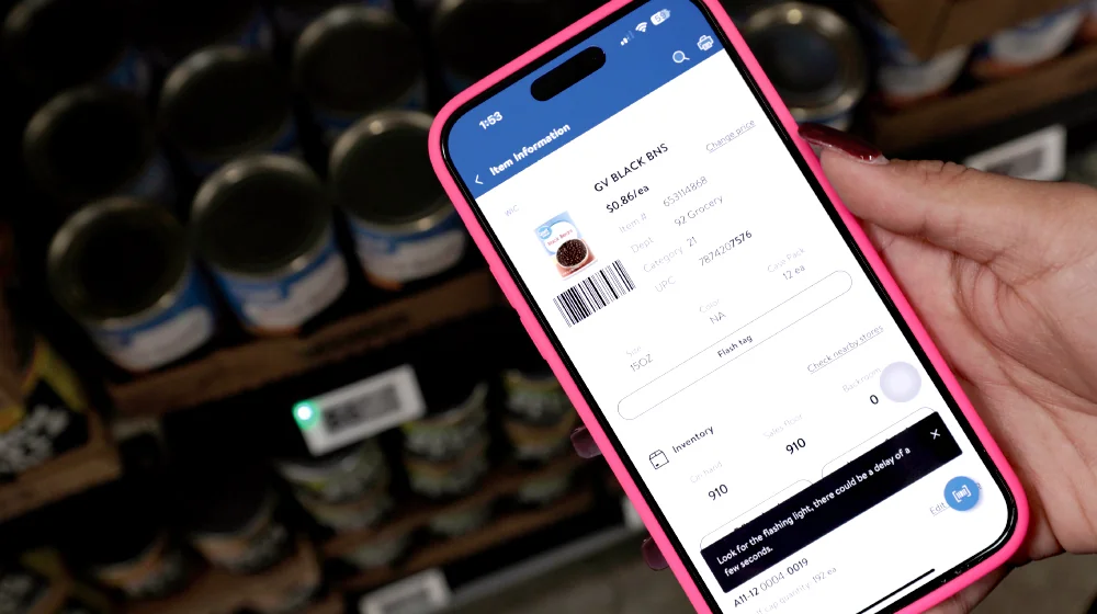 Walmart’s handheld product screen includes Flash tag, with the corresponding shelf label visibly illuminated in the background.