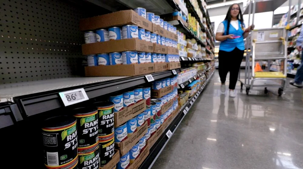 An illuminated shelf label guides a Walmart associate during replenishment.